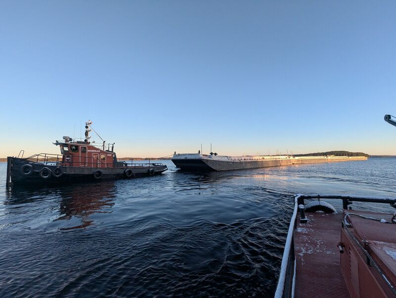 Hinaaja ja proomu auringonlaskussa