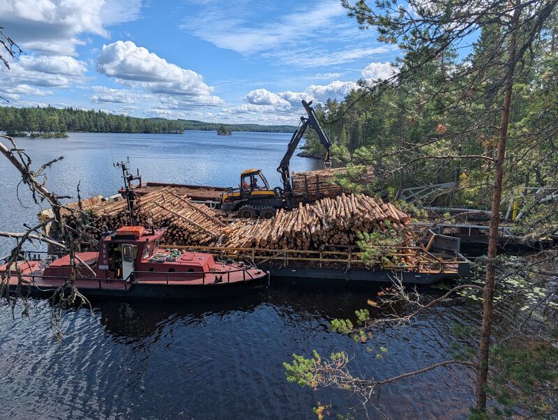 Hinaaja ja puutavaraproomu rannassa